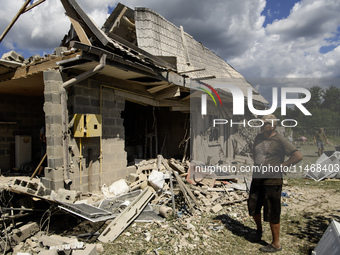 Local residents are cleaning up the residential building in a village in the Kyiv region, heavily damaged during a massive Russian missile a...