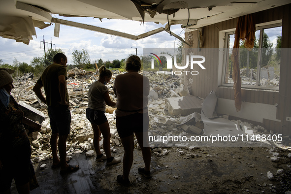 Local residents are cleaning up the residential building in a village in the Kyiv region, heavily damaged during a massive Russian missile a...