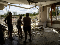 Local residents are cleaning up the residential building in a village in the Kyiv region, heavily damaged during a massive Russian missile a...