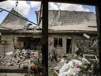 Local residents are cleaning up the residential building in a village in the Kyiv region, heavily damaged during a massive Russian missile a...