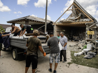 Local residents are cleaning up the residential building in a village in the Kyiv region, heavily damaged during a massive Russian missile a...