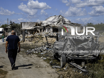 A local resident is standing next to a residential building in a village in the Kyiv region, heavily damaged during a massive Russian missil...