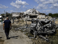 A local resident is standing next to a residential building in a village in the Kyiv region, heavily damaged during a massive Russian missil...