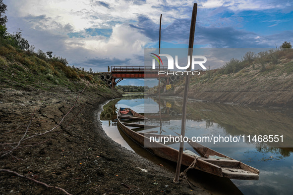 A man is walking on an Iron Bridge as the level of water bodies has decreased, leaving boats on the shores and triggering a drought-like sit...