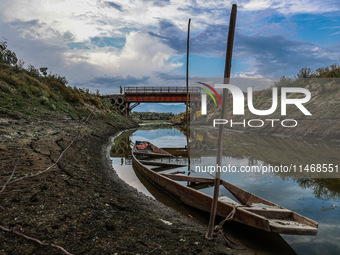 A man is walking on an Iron Bridge as the level of water bodies has decreased, leaving boats on the shores and triggering a drought-like sit...