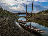 A man is walking on an Iron Bridge as the level of water bodies has decreased, leaving boats on the shores and triggering a drought-like sit...