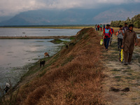 Fishermen are walking back after completing their day's work at Wular Lake in Sopore, Jammu and Kashmir, India, on August 11, 2024. (