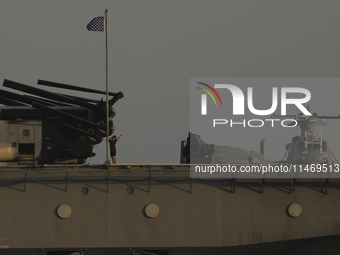 Crew members stand aboard the amphibious assault ship USS Wasp (LHD-1) docked at Limassol Port, amid rising tensions in the Middle East, in...