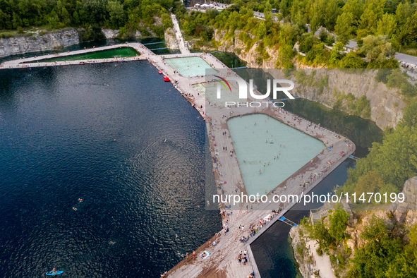 An aerial view of people refreshing and sunbathing during a warm evening in Zakrzowek, a popular resort in Krakow, Poland on August 11, 2024...