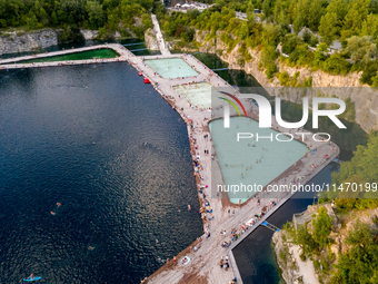 An aerial view of people refreshing and sunbathing during a warm evening in Zakrzowek, a popular resort in Krakow, Poland on August 11, 2024...