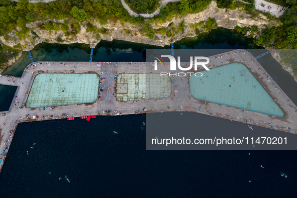 An aerial view of people refreshing and sunbathing during a warm evening in Zakrzowek, a popular resort in Krakow, Poland on August 11, 2024...