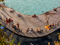 People refresh and sunbathe during a sunset of warm evening in Zakrzowek, a popular resort in Krakow, Poland on August 11, 2024. According t...