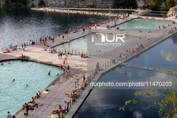 People refresh and sunbathe during a sunset of warm evening in Zakrzowek, a popular resort in Krakow, Poland on August 11, 2024. According t...