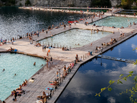 People refresh and sunbathe during a sunset of warm evening in Zakrzowek, a popular resort in Krakow, Poland on August 11, 2024. According t...