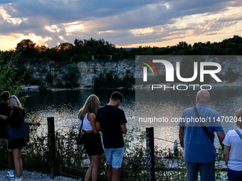 People watch a sunset during a warm evening in Zakrzowek, a popular resort in Krakow, Poland on August 11, 2024. According to the EU's clima...