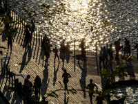 People refresh and sunbathe during a sunset of warm evening in Zakrzowek, a popular resort in Krakow, Poland on August 11, 2024. According t...