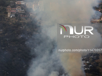 A forest fire is burning near the village of Larbaa Nath Reten, Tizi Ouzou, in the mountainous region of Kabyle, Algeria, on August 11, 2024...