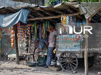 A man is selling packets of snuff and dried snacks along the roadside in Haldwani, Uttarakhand, India, on April 23, 2024. (