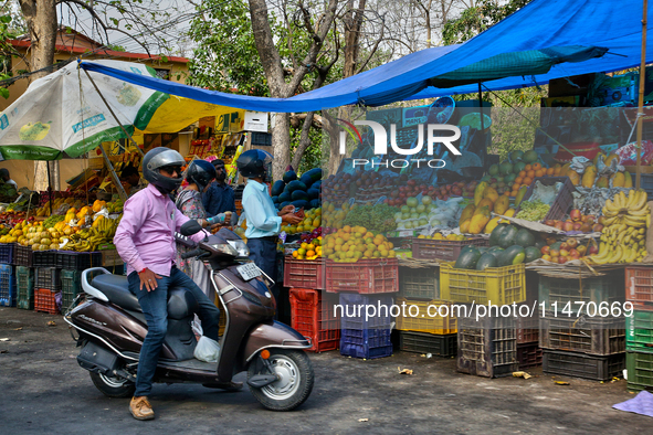 People are buying fresh fruit at a fruit stand along the roadside in Haldwani, Uttarakhand, India, on April 23, 2024. 