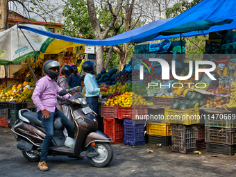 People are buying fresh fruit at a fruit stand along the roadside in Haldwani, Uttarakhand, India, on April 23, 2024. (