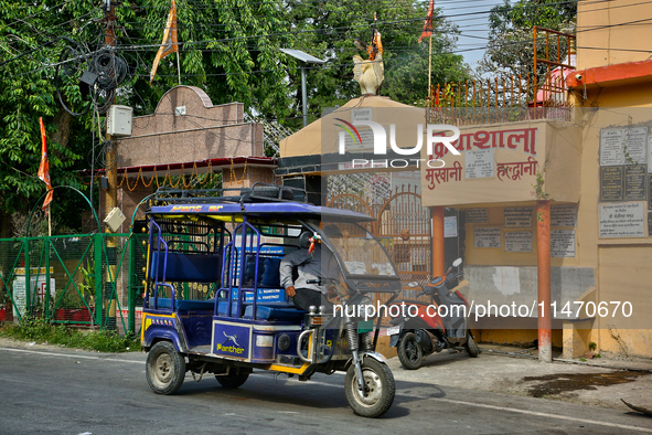 An auto-rickshaw is traveling along the road in Haldwani, Uttarakhand, India, on April 23, 2024. 