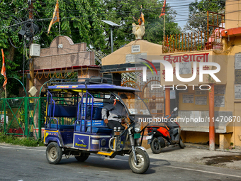 An auto-rickshaw is traveling along the road in Haldwani, Uttarakhand, India, on April 23, 2024. (