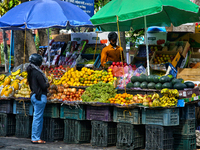 A woman is buying fresh fruit at a fruit stand along the roadside in Haldwani, Uttarakhand, India, on April 23, 2024. (