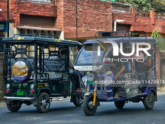 Auto-rickshaws are traveling along the road in Haldwani, Uttarakhand, India, on April 23, 2024. (