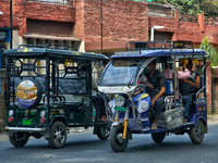 Auto-rickshaws are traveling along the road in Haldwani, Uttarakhand, India, on April 23, 2024. (