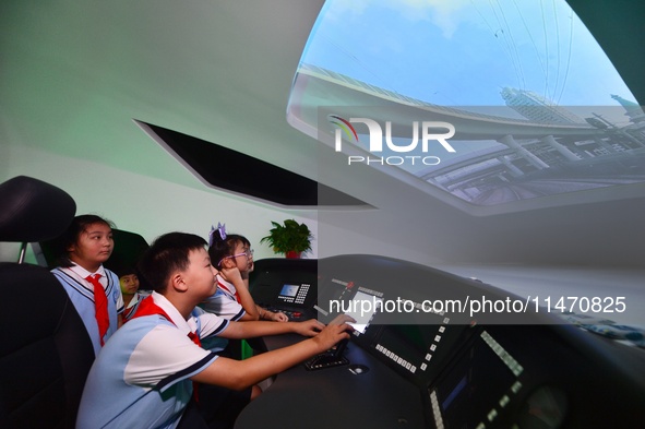 Primary school children are experiencing high-speed train simulation driving at Jiaoji Railway Museum in Qingdao, Shandong province, China,...