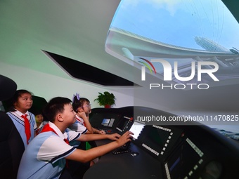 Primary school children are experiencing high-speed train simulation driving at Jiaoji Railway Museum in Qingdao, Shandong province, China,...