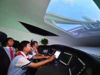 Primary school children are experiencing high-speed train simulation driving at Jiaoji Railway Museum in Qingdao, Shandong province, China,...