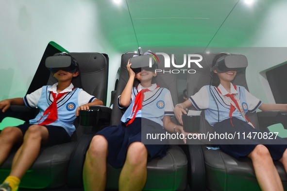 Primary school children are experiencing a VR4D image of high-speed rail at the Jiaoji Railway Museum in Qingdao, Shandong province, China,...