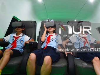 Primary school children are experiencing a VR4D image of high-speed rail at the Jiaoji Railway Museum in Qingdao, Shandong province, China,...