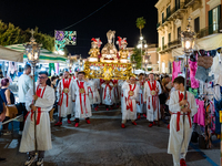 Members of the confraternity are carrying the statue of the Three Saints of Bisceglie during the procession through the town centre, in Bisc...