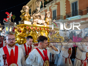 Members of the confraternity are carrying the statue of the Three Saints of Bisceglie during the procession through the town centre, in Bisc...