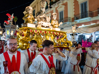 Members of the confraternity are carrying the statue of the Three Saints of Bisceglie during the procession through the town centre, in Bisc...