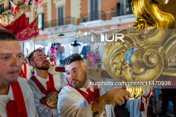 Members of the confraternity are carrying the statue of the Three Saints of Bisceglie during the procession through the town centre, in Bisc...