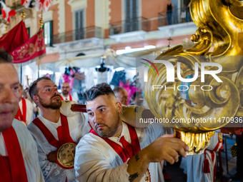 Members of the confraternity are carrying the statue of the Three Saints of Bisceglie during the procession through the town centre, in Bisc...