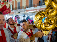 Members of the confraternity are carrying the statue of the Three Saints of Bisceglie during the procession through the town centre, in Bisc...