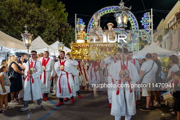 Members of the confraternity are carrying the statue of the Three Saints of Bisceglie during the procession through the town centre, in Bisc...