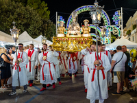 Members of the confraternity are carrying the statue of the Three Saints of Bisceglie during the procession through the town centre, in Bisc...