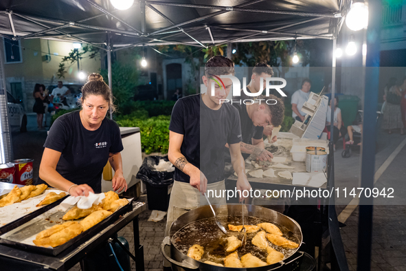 A boy is frying panzerotti for sale during the patronal feast of the Three Saints of Bisceglie, in Bisceglie, on August 11, 2024. Bisceglie...