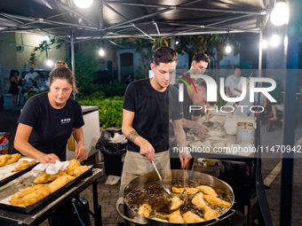 A boy is frying panzerotti for sale during the patronal feast of the Three Saints of Bisceglie, in Bisceglie, on August 11, 2024. Bisceglie...