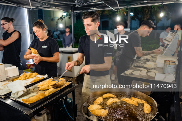 A boy is frying panzerotti for sale during the patronal feast of the Three Saints of Bisceglie, in Bisceglie, on August 11, 2024. Bisceglie...