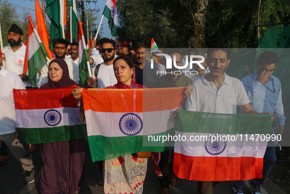 People are holding Indian National flags during the Tiranga Rally ahead of India's Independence Day celebrations in Srinagar, Jammu and Kash...