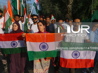 People are holding Indian National flags during the Tiranga Rally ahead of India's Independence Day celebrations in Srinagar, Jammu and Kash...