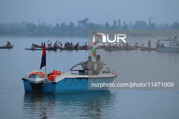 Indian policemen are standing alert on a motorboat during the Tiranga Rally ahead of India's Independence Day celebrations in Srinagar, Jamm...