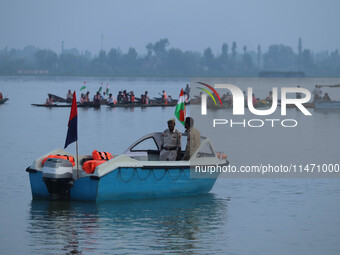 Indian policemen are standing alert on a motorboat during the Tiranga Rally ahead of India's Independence Day celebrations in Srinagar, Jamm...