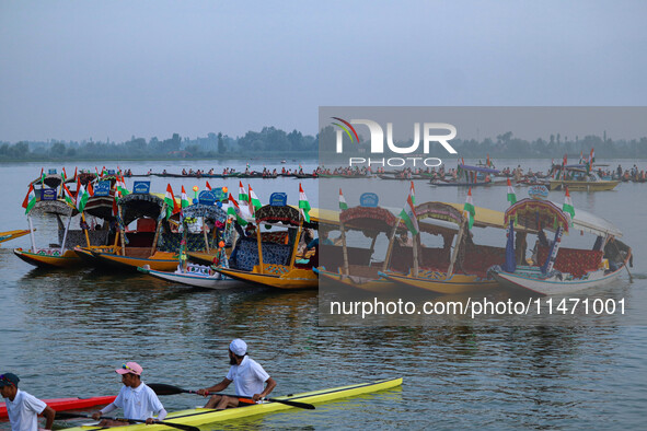 Men are rowing boats as they take part in the Tiranga Rally ahead of India's Independence Day celebrations in Srinagar, Jammu and Kashmir, o...